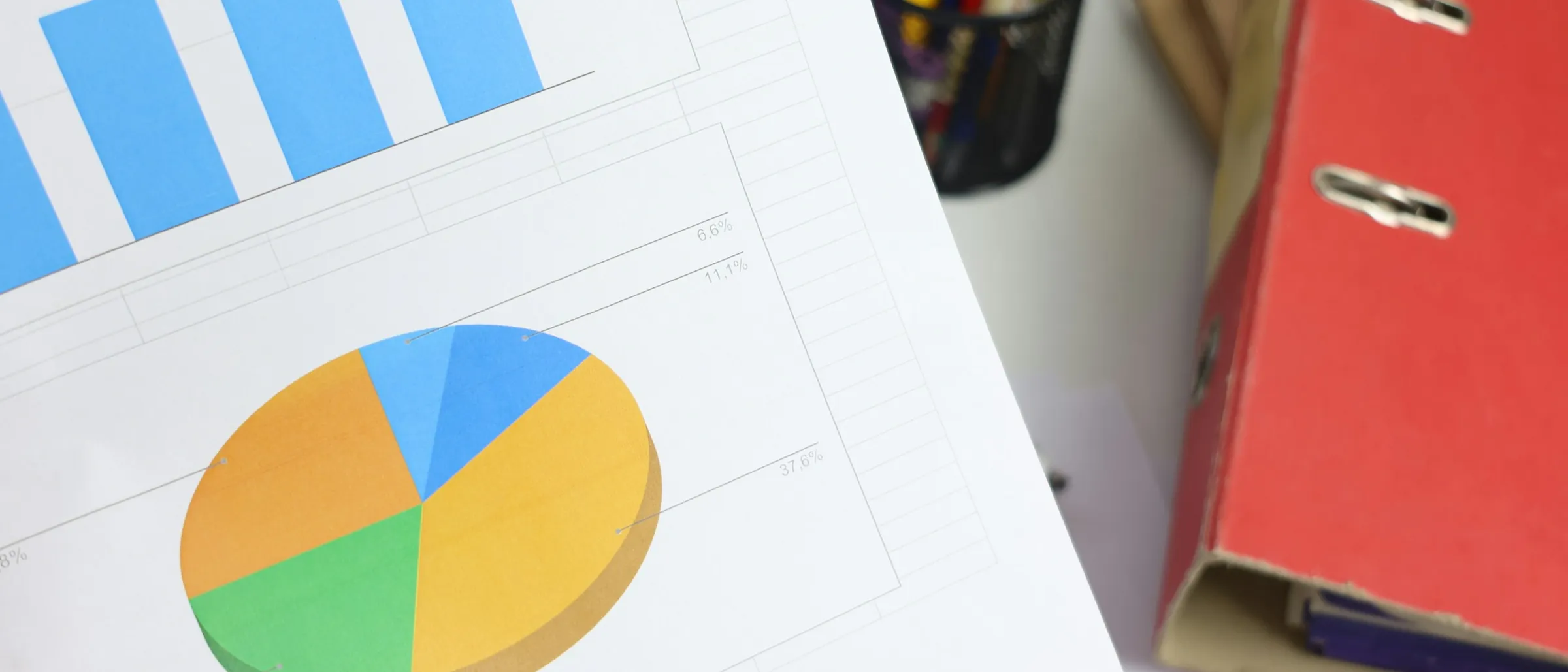 A printed financial report with bar and pie charts across the page