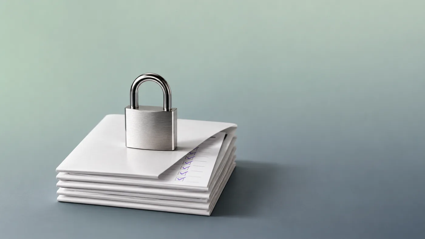 A padlock resting on a stack of checked documents, representing Vigor's goAML, legal and compliance services in Dubai