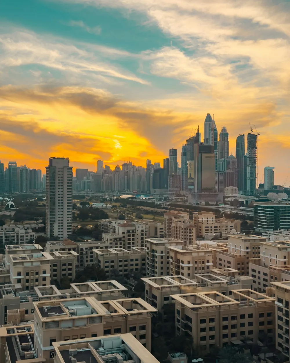 The Dubai skyline at sunset, the city lit gold behind Sheikh Zayed Road